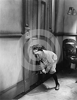 Teenage boy peeping through keyhole