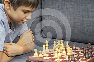 Teenage boy playing chess game at home. Education, strategic board game, education, leisure, entertainment at home