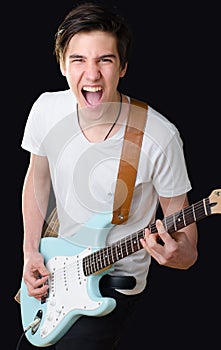 Teenage boy playing electric guitar and singing