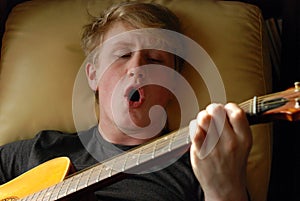 Teenage boy playing guitar and singing