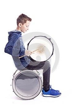 Teenage boy plays drum in studio