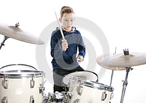 Teenage boy plays drums in studio