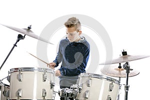 Teenage boy plays drums in studio