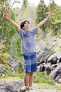 Teenage boy raising hands in praise