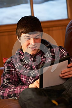 Teenage Boy Relaxing On Sofa With Tablet Computer