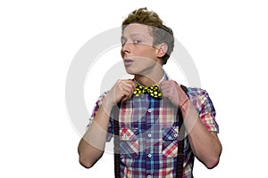 Teenage boy`s trying on new bow tie.