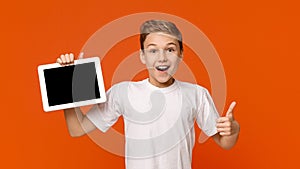 Teenage boy showing blank digital tablet screen