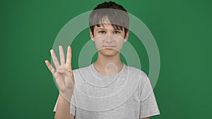 Teenage boy showing numbers with fingers from 1 to 5, counting one, two, three, four, five on green screen chroma key