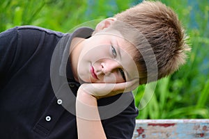 Teenage boy sitting on a bench