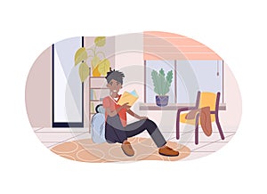 Teenage boy sitting on floor and reading book