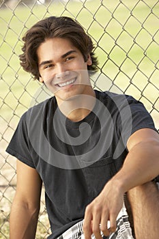 Teenage Boy Sitting In Playground