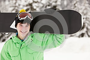 Teenage Boy With Snowboard On Ski Holiday