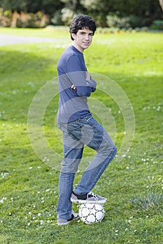 Teenage Boy Standing On Soccer Ball photo