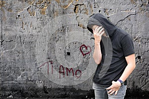 Ti amo graffiti and unhappy boy with black hoodie photo
