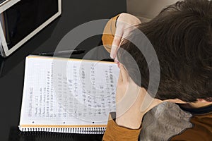 Teenage boy studying with digital tablet at home