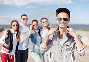 Teenage boy with sunglasses and friends outside