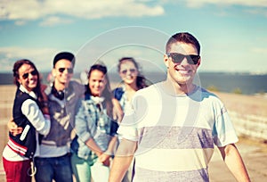 Teenage boy with sunglasses and friends outside
