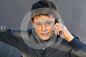 Teenage boy using cellphone, he gets bad news