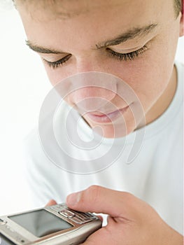 Teenage boy using cellular phone and smiling