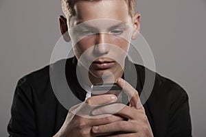 Teenage boy using mobile phone, head and shoulders, crop