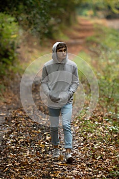 Teenage boy walking alone on an atumn day