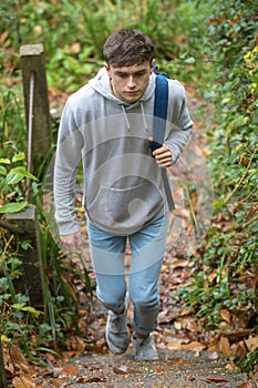 Teenage boy walking up concrete steps