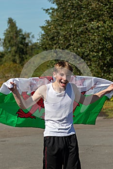 Teenage boy waving the Welsh Flag