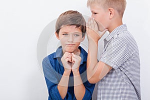 Teenage boy whispering in the ear a secret to