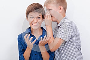 Teenage boy whispering in the ear a secret to