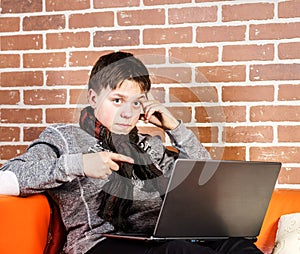 Teenage boy working on laptop. Concentration and composure.