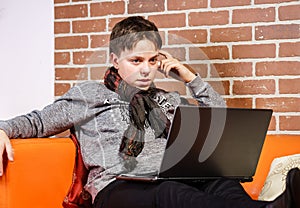 Teenage boy working on laptop. Concentration and composure.