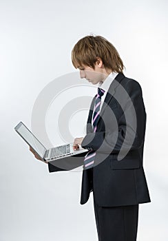 Teenage boy working in white laptop