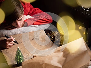 Teenage boy writing long letter to Santa