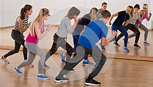 Teenage boys and girls learning in dance hall