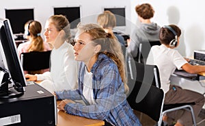 Teenage boys and girls using computers in IT class room