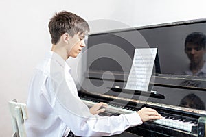 Teenage boys play piano in class or at home .