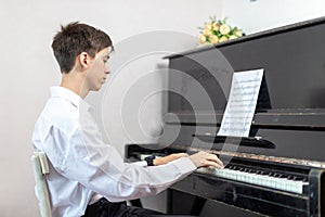 Teenage boys play piano in class or at home .