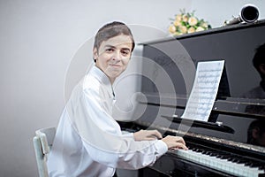 Teenage boys play piano in class or at home .