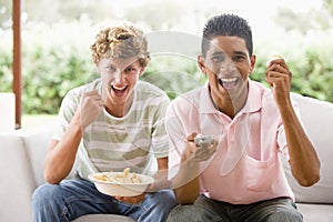 Teenage Boys Sitting On Couch Eating crisps