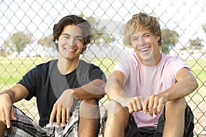 Teenage Boys Sitting In Playground photo