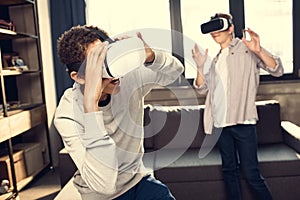 Teenage boys wearing virtual reality headsets at home