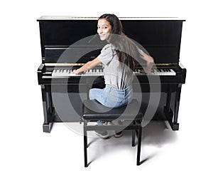 Teenage brunette girl and black upright piano in studio