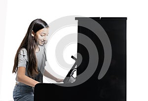 Teenage brunette girl and black upright piano in studio