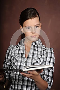 Brunette girl reading a book and looking amazed