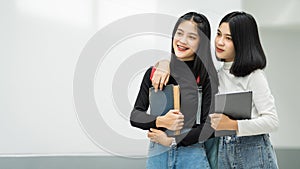 Teenage college friend students walking and chatting in college campus while having break after class. Two happy students walking