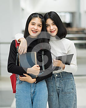 Teenage college friend students walking and chatting in college campus while having break after class. Two happy students walking