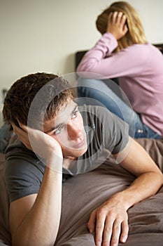 Teenage Couple In Bedroom After Argument