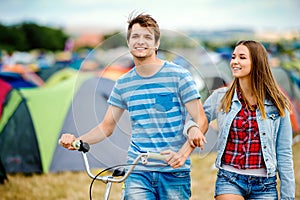 Teenage couple with bike at summer music festival