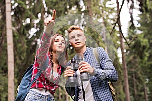 Teenage couple hiking in forest. Summer vacation.