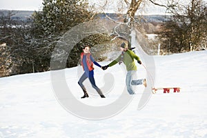 Adolescente tracción trineo a través de nevado 